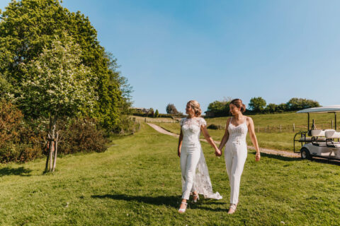 A&C(632) Amy and Charlotte walking across the Estate grounds after their ceremony